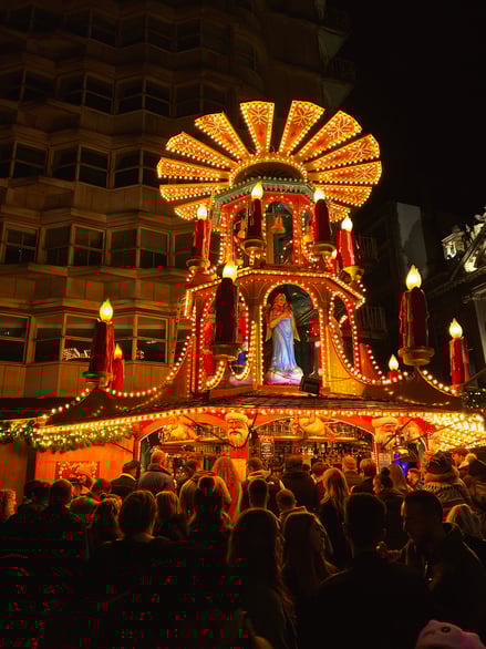 Crowded Birmingham Christmas Market with illuminated festive stall at night