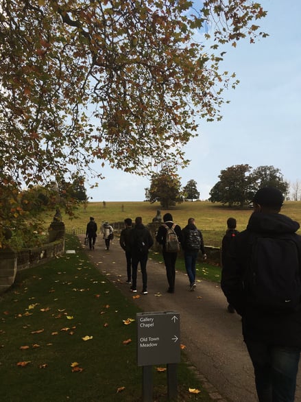 Students walking through parkland towards open fields