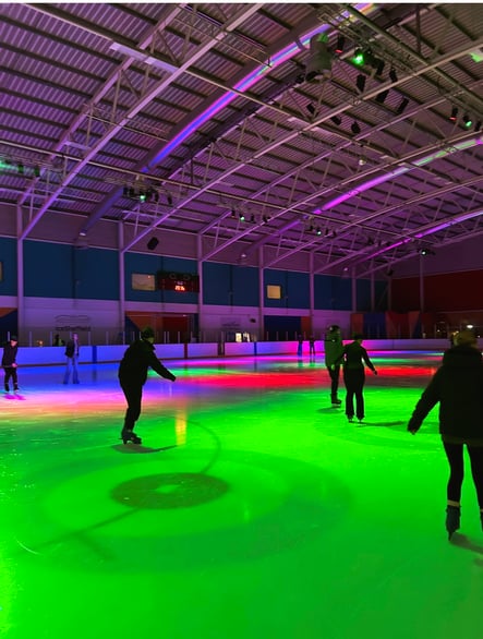 People ice skating indoors under colourful lighting at a Sheffield rink