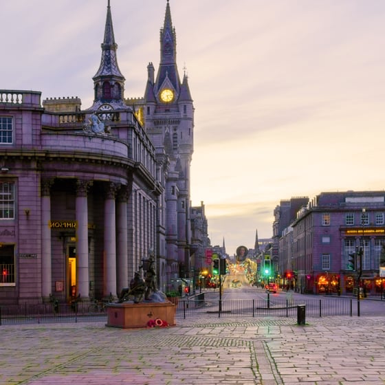 Student with phone in front of Aberdeen landmarks