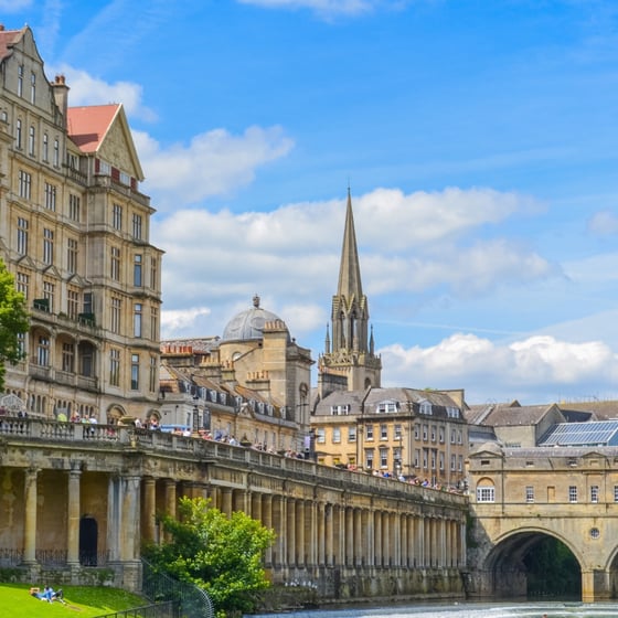 Student with phone in front of Bath landmarks