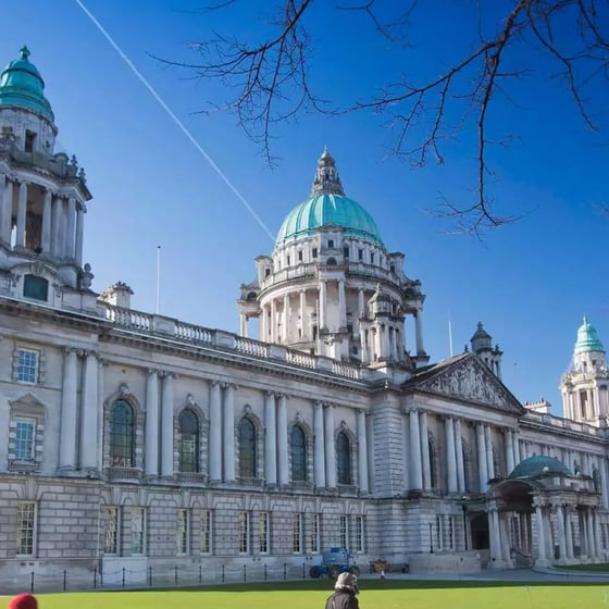 Student with phone in front of Belfast landmarks