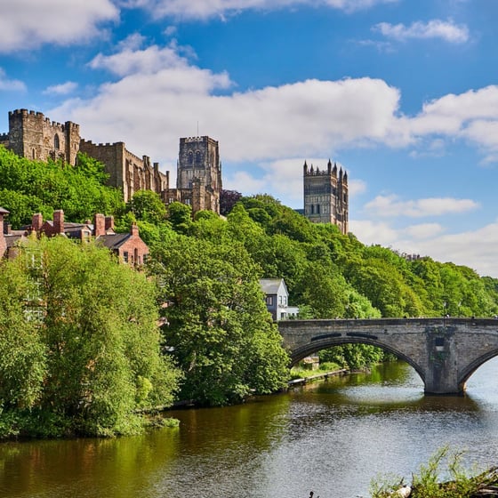 Student with phone in front of Durham landmarks