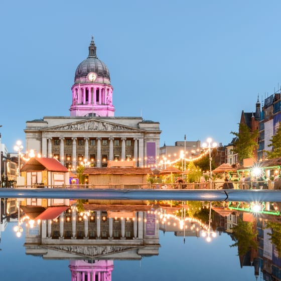 Student with phone in front of Nottingham landmarks
