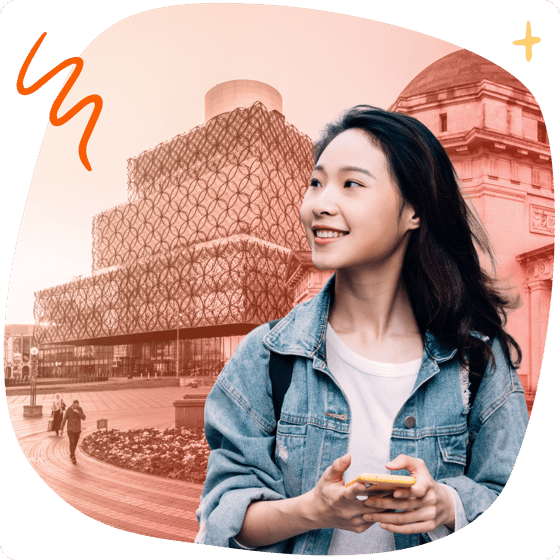 Student with phone in front of Birmingham landmarks