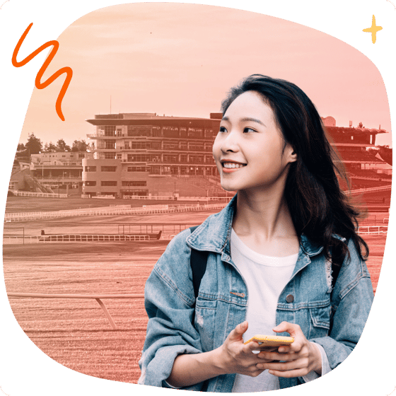 Student with phone in front of Cheltenham landmarks