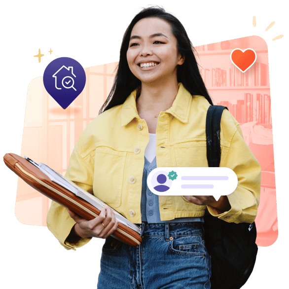 A smiling female student in a yellow shirt and jeans is walking while carrying a laptop in a case in her right hand